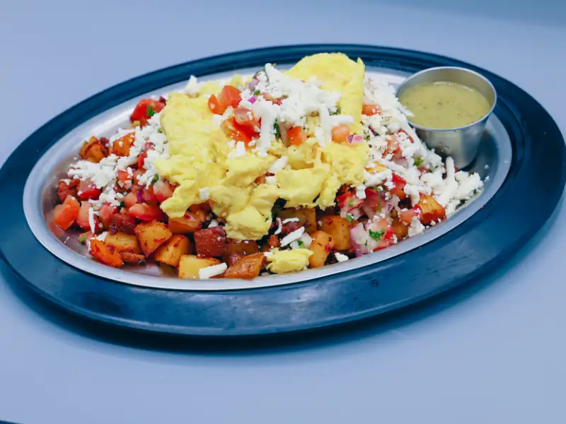 Country potatoes topped with tomatoes, cheese and eggs.