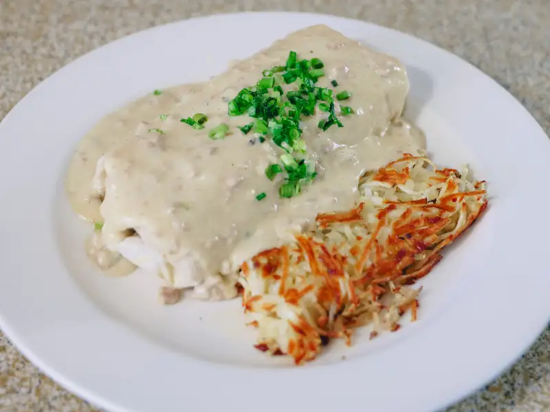 Scrambled eggs, sausage, bacon, cheddar cheese. Burrito smothered in house-made gravy and served with hashbrowns.