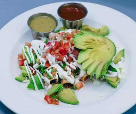 Chicken taquitos topped with lettuce, pico, sour cream, avocado, queso fresco.