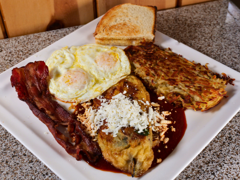 Chile poblano stuffed with queso fresco, two eggs, home fries and two strips of bacon.